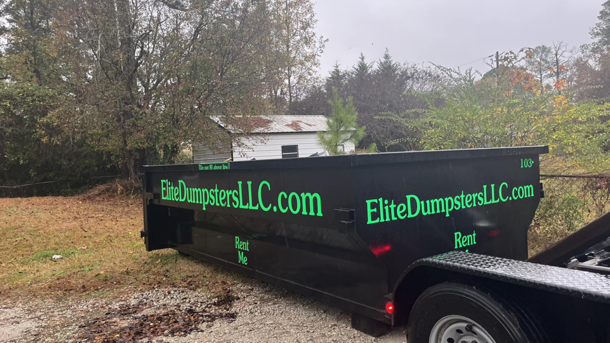 Waste disposal truck with Elite Dumpsters and Disposal LLC branding on the rear storage container
