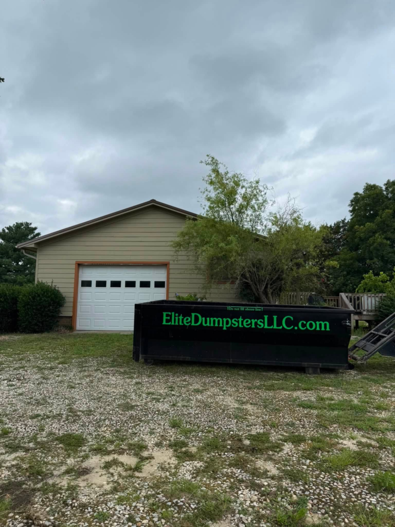 A garage with a dumpster in front of it 